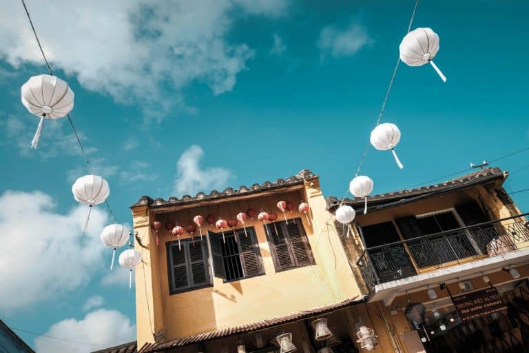 white paper lanterns hanged near beige concrete house