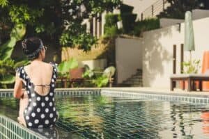 woman sitting beside pool near house during daytime