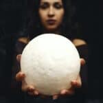 Woman Holding a Moon Shaped Ball on Stretched Out Hands