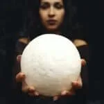 Woman Holding a Moon Shaped Ball on Stretched Out Hands