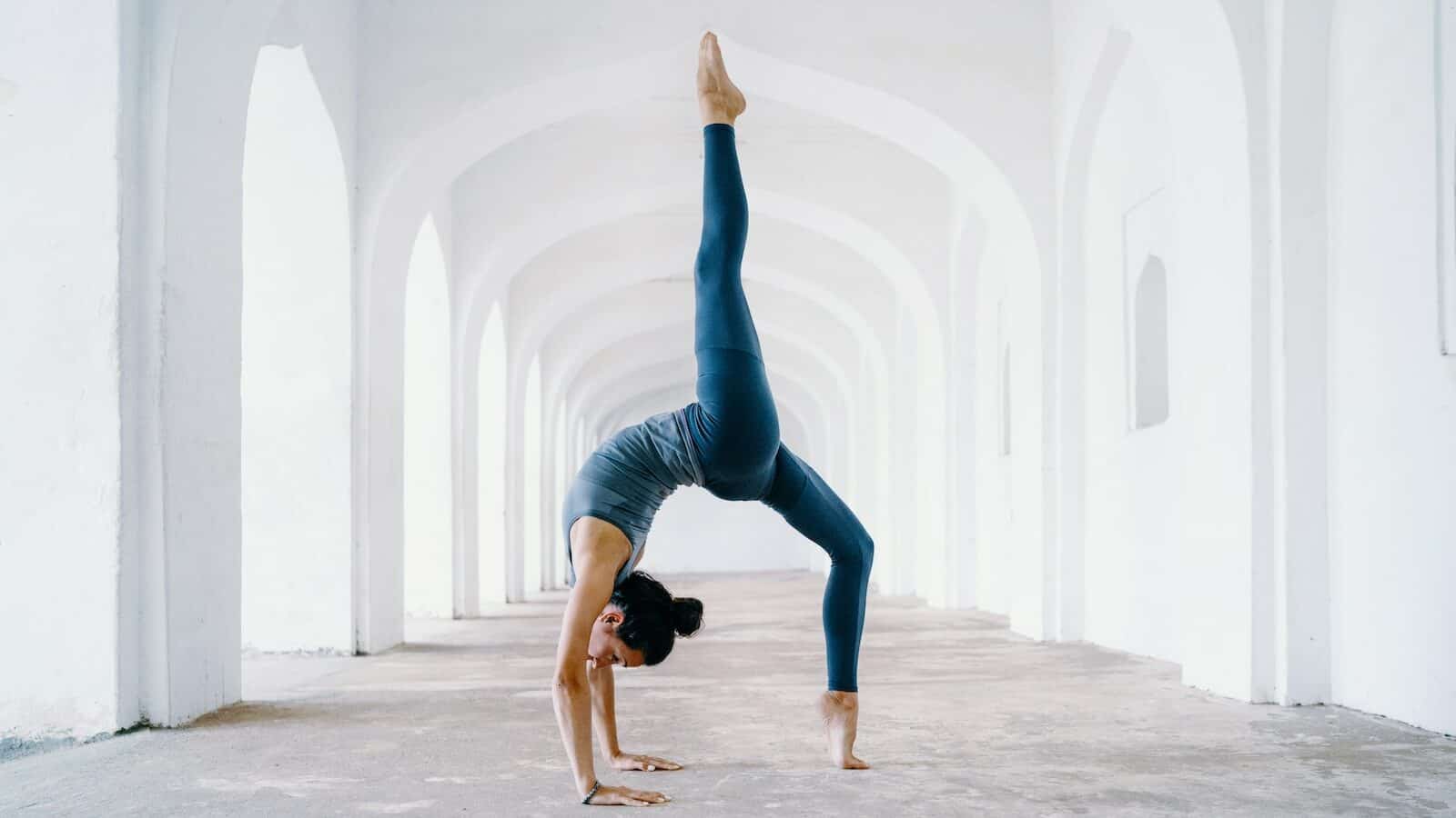 woman in blue leggings and black tank top doing yoga
