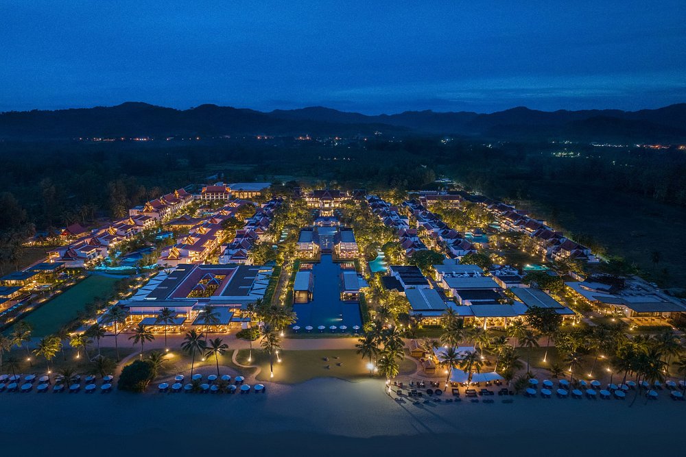 Aerial night view of illuminated resort by beach.