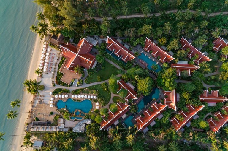 Aerial view of beach resort with red-roofed buildings.