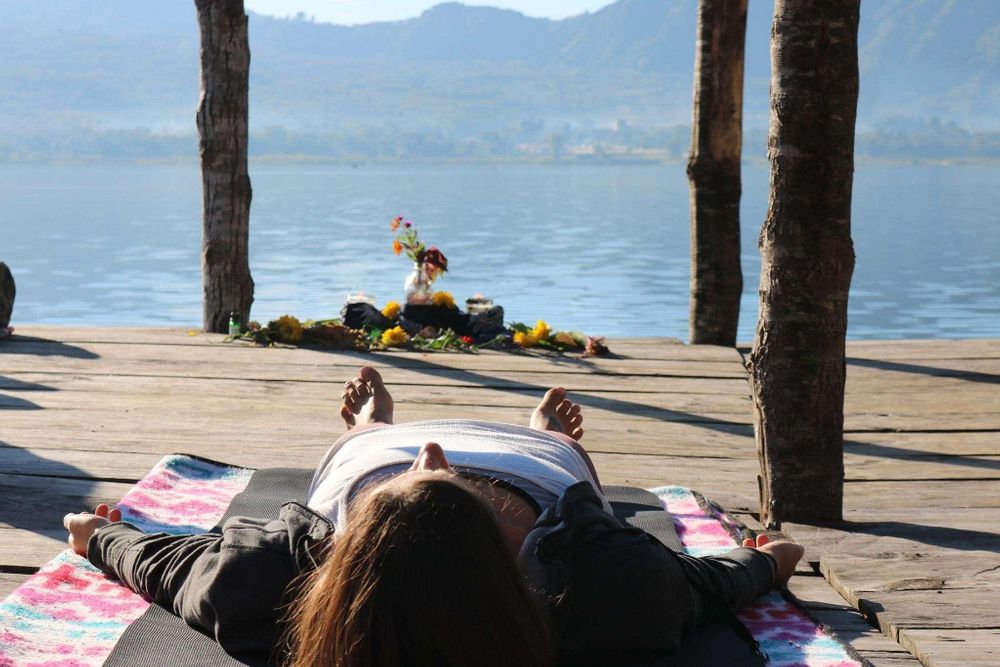 Person relaxing on dock by serene lake