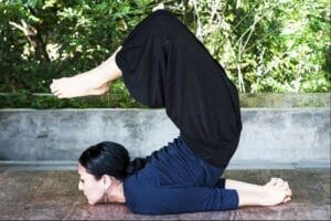 Woman performing advanced yoga pose on floor