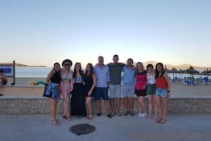 Group posing by beach at sunset
