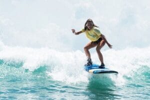 Young girl surfing on ocean wave