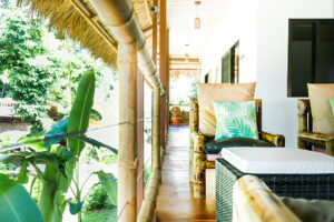 Tropical veranda with bamboo railing and cushioned chairs