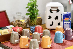 Colorful mugs on tea and coffee station