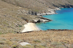 Secluded sandy cove with turquoise water and cliffs