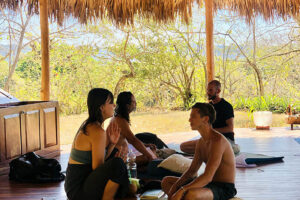 Group meditating in open-air yoga pavilion