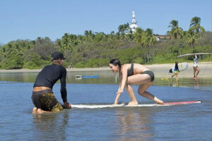 Woman learning to surf in shallow water