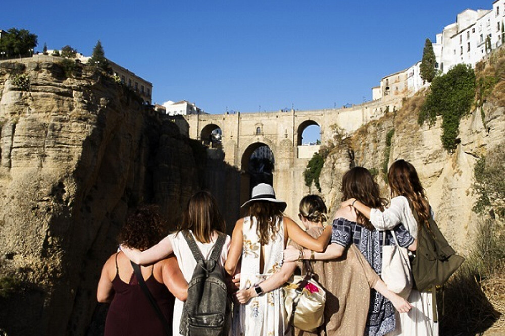 Friends overlooking historic stone bridge and canyon