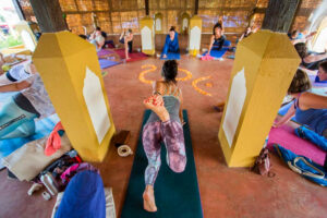 Group yoga class practicing poses in warm studio