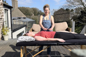 Woman receiving outdoor massage therapy on deck
