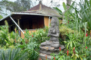 Stone deity statue in lush tropical garden