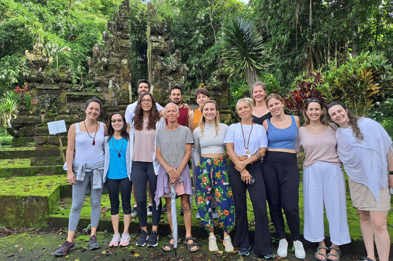 Group posing before lush temple ruins