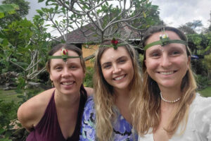 Three women wearing leaf headbands outdoors