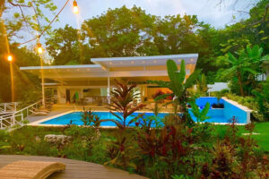 Modern tropical villa with pool at dusk