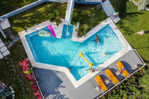 Aerial view of modern backyard pool with floats