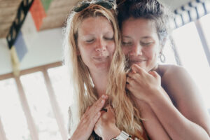 Two women embracing with eyes closed indoors
