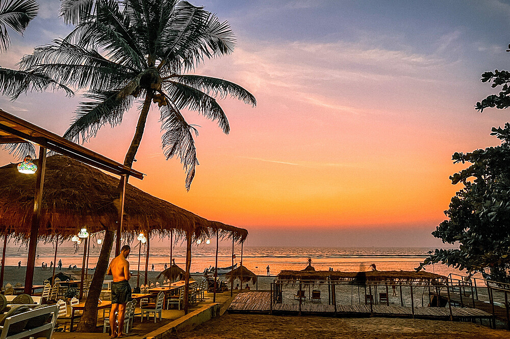 Sunset beach with palm tree and huts