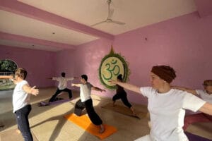 Group yoga class practicing warrior pose indoors