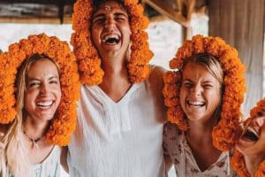 Four women laughing with marigold flower garlands