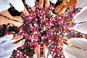 Bare feet in circle on colorful flower petals