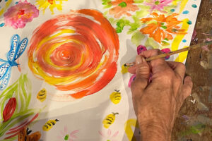 Hand painting colorful flowers and bees on paper