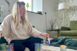 Woman performing sound therapy with crystal singing bowls