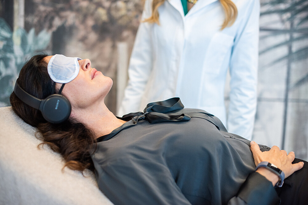 Woman wearing eye mask and headphones during spa session