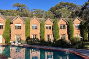 Brick townhouses with pool and tall trees