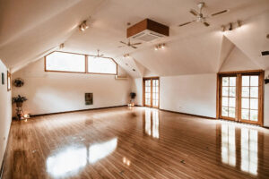 Spacious sunlit studio with polished wooden floors