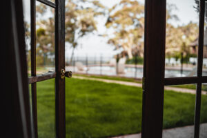 Open window overlooking green lawn and pool