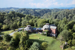 Aerial view of house surrounded by forested hills