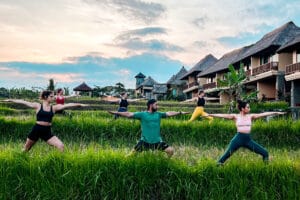 Group practicing yoga in lush rice field