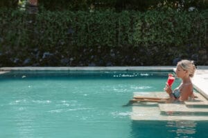Woman relaxing in pool with red drink