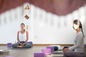 Two women meditating in a yoga studio