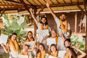 Group celebrating with certificates and flower leis