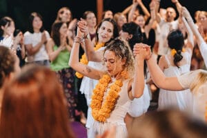 Woman wearing flower garland dancing in group celebration