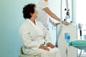 Elderly woman beside medical device with clinician