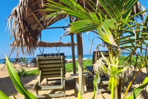 Thatched umbrella and lounge chairs on tropical beach