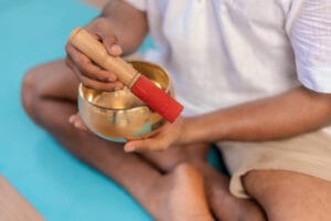 Person holding Tibetan singing bowl and mallet