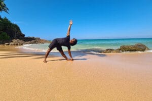Person doing yoga on sunny beach