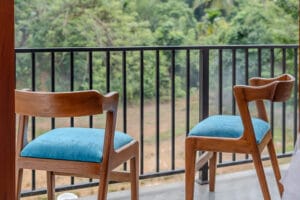 Two wooden chairs on balcony overlooking greenery