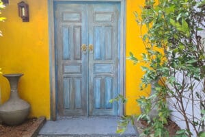 Blue double doors against bright yellow wall
