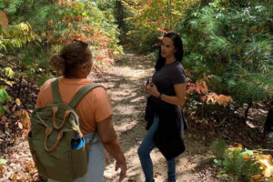 Two women hiking on a forest trail