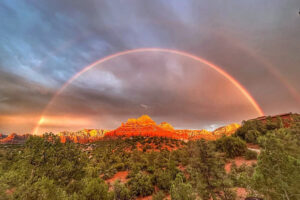 Full rainbow over red rock desert landscape