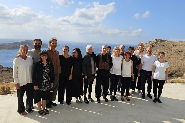 Group posing on terrace overlooking ocean cliffs